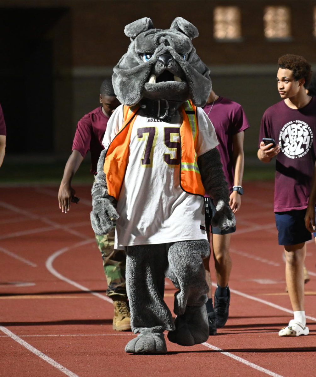 The Bulldog walks the track in construction gear ahead of the football team's home opener. 