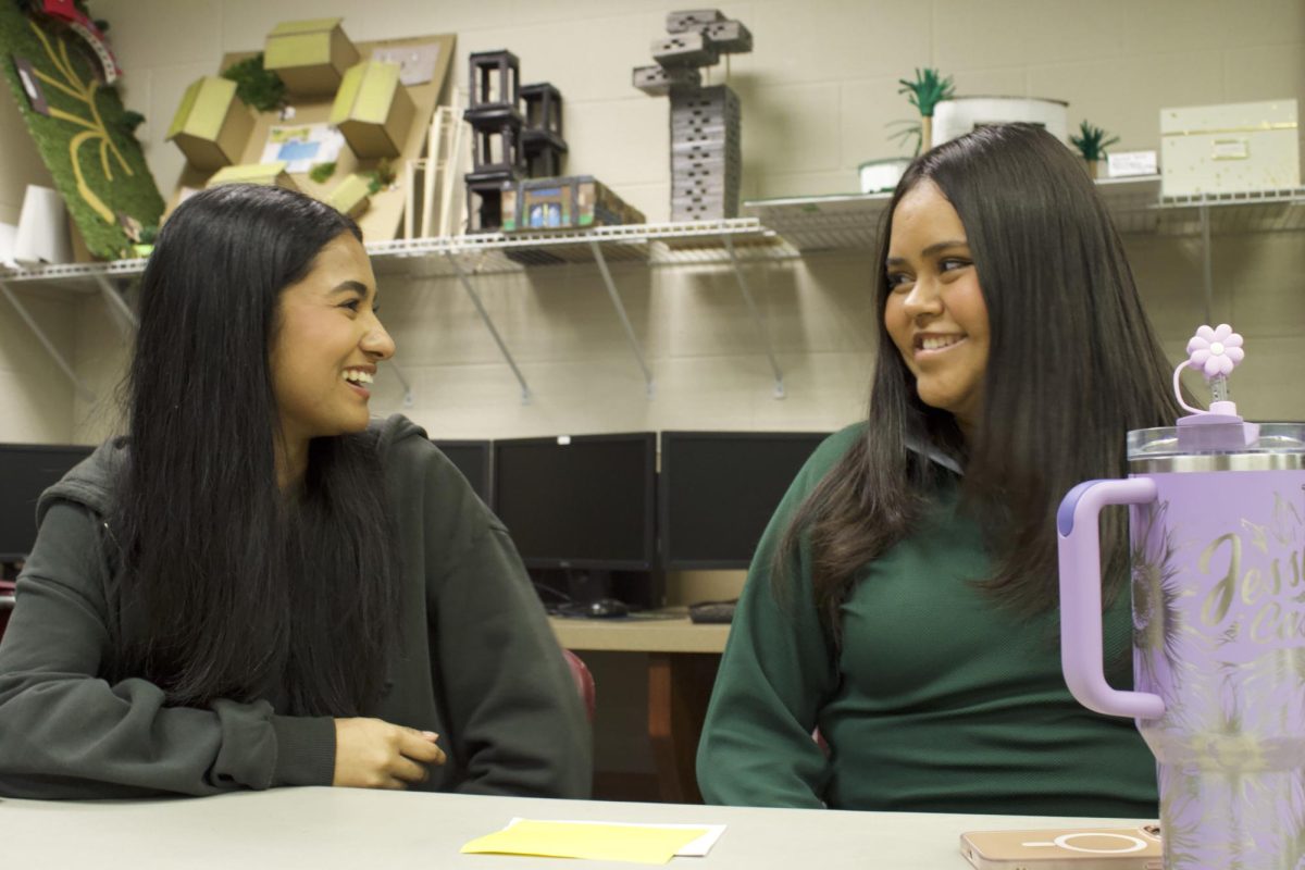 Architecture students converse and smile while in class 