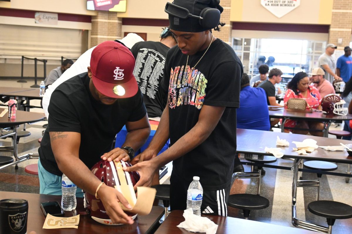 Junior Jamicah Jones and his dad participate in the Dads and Decals event.