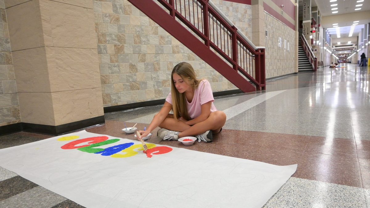 Senior Haven Nilson helps decorate the halls for Homecoming.