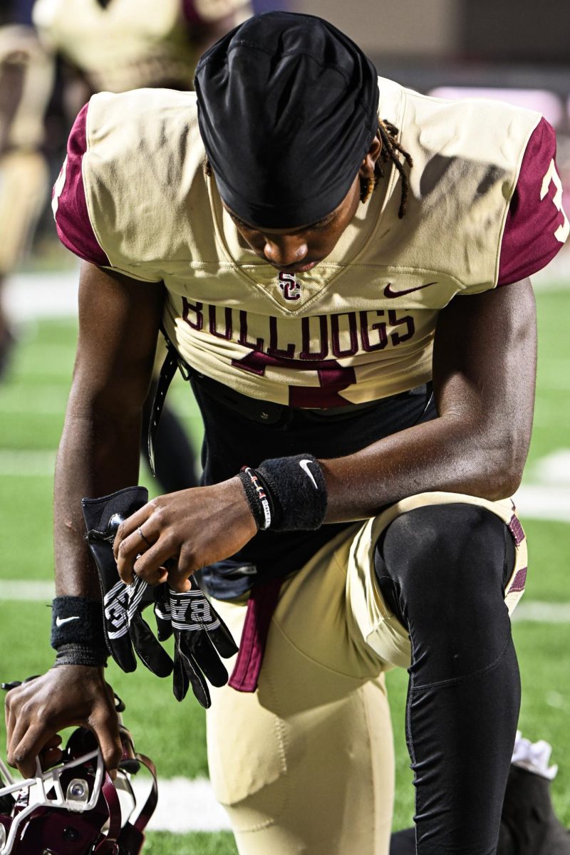 Ahead of the game against Goose Creek Memorial, Brandon Jones prays on the field. 