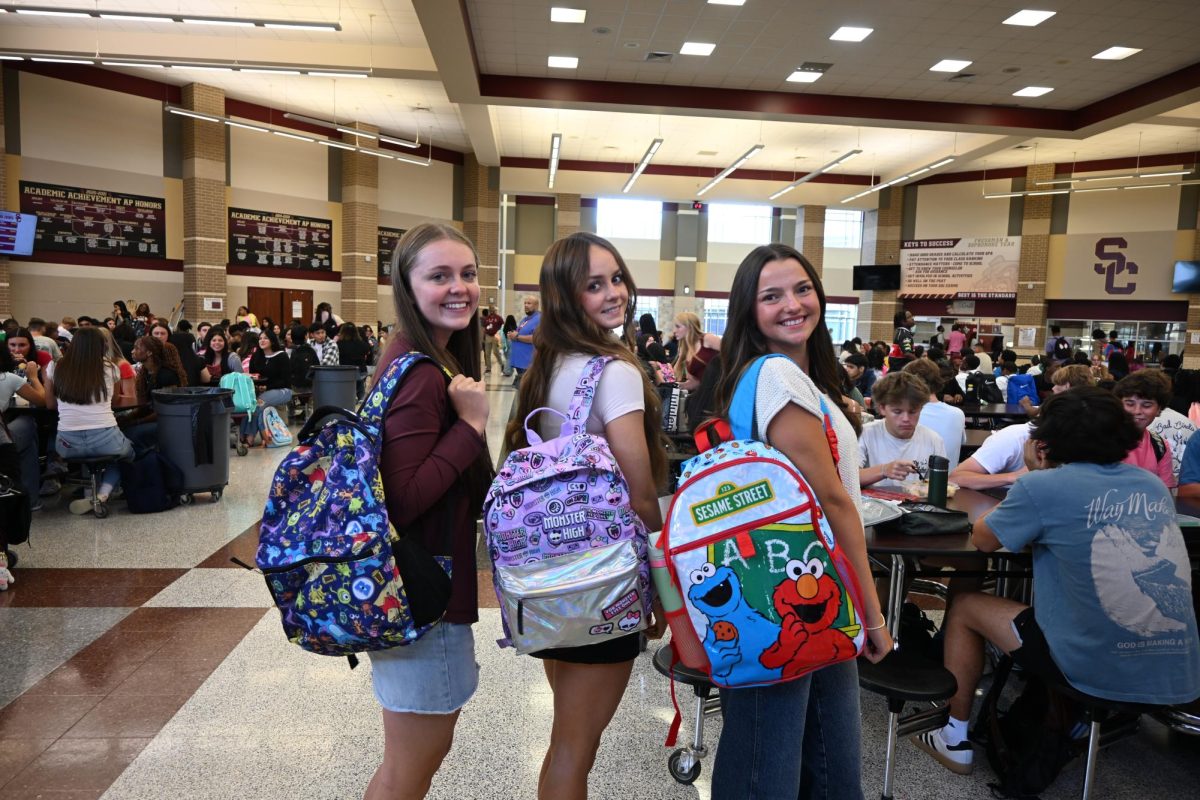 Mya Harrison, Kinsley Mollohan and Reese Shevchek pose with their senior backpacks the first day of school