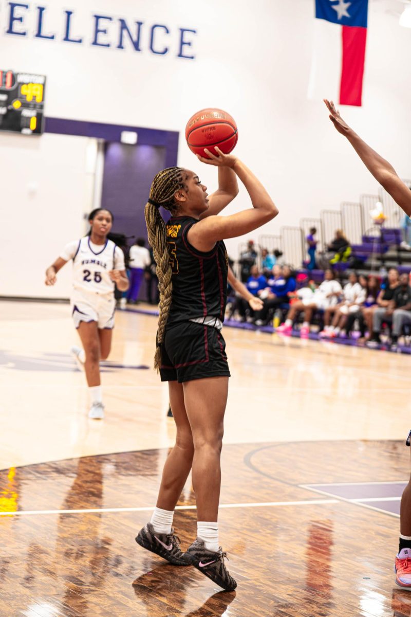 Junior Kyri Brown shoots a contested mid-range shot against an Humble defender.